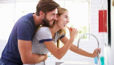 couple brushes their teeth