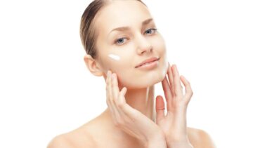 woman applies cream on her face